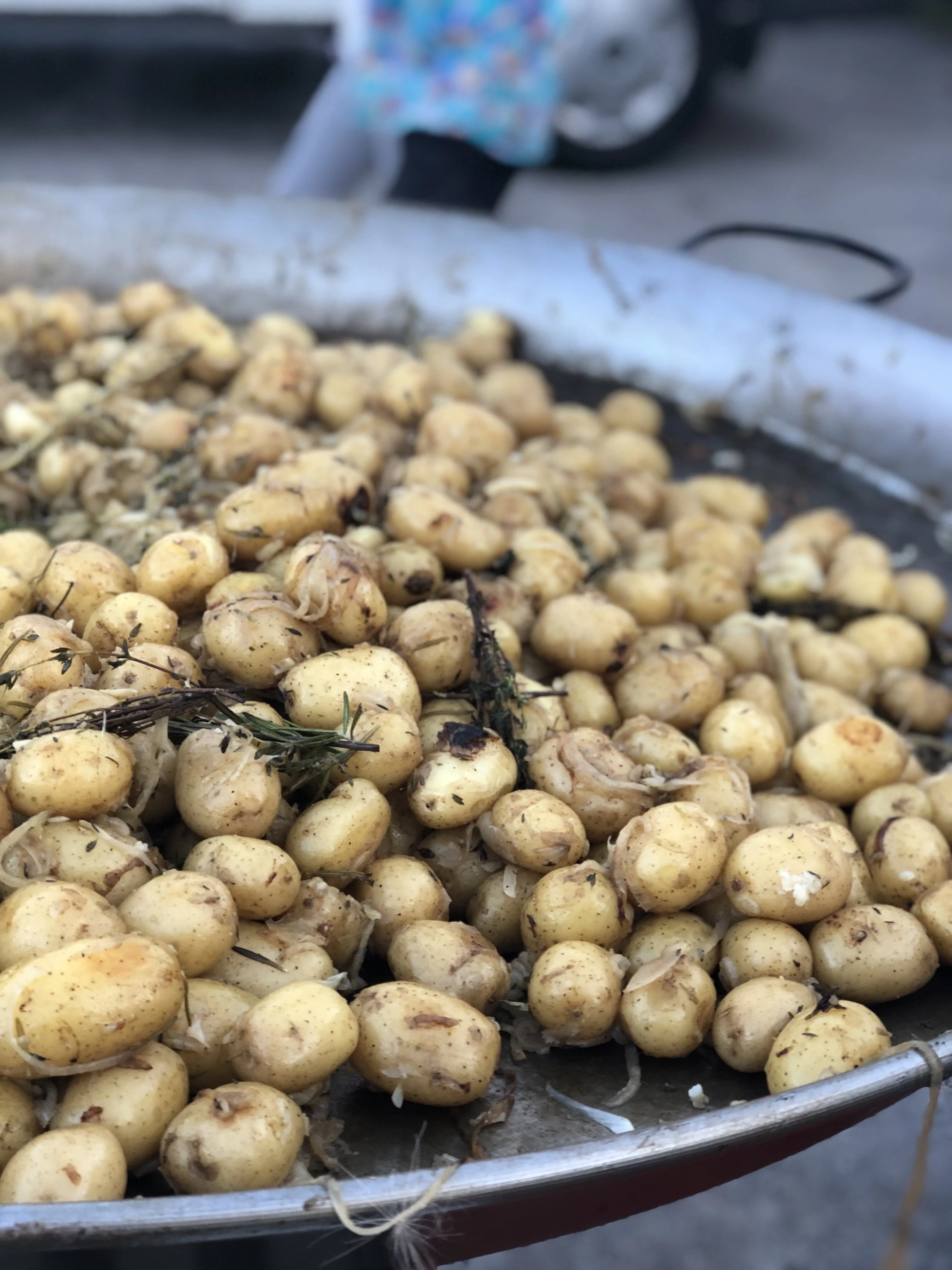 Garlic and herb potatoes cooking in a large pan